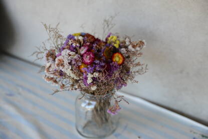 Osušeno poljsko cvijeće u staklenoj vazi na stolu.