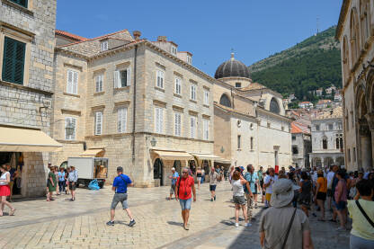 Dubrovnik, Hrvatska: Grupa turista u starom gradu. Dubrovnik, Hrvatska: Grupa turista u starom gradu. Ljudi šetaju centrom grada. Stare zidine i zgrade u Dubrovniku. Popularno turističko odredište na Jadranskom moru. Stradun.