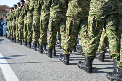 Vojnici u uniformama marširaju ulicom.