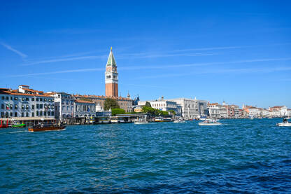 Venecija, Italija: Historijske građevine uz riječni kanal. Čamci na vodi. Popularno turističko odredište.