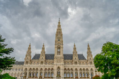 Beč, Austrija: gradska vijećnica na Rathausplatzu sa dramatičnim tamnim oblacima u pozadini. Kancelarija gradonačelnika Beča, sjedište gradskog vijeća i lokalne samouprave.