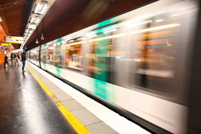 Zamućen voz se kreće brzo u željezničkoj stanici. Putnici se ukrcavaju u metro. Stanica podzemne željeznice. Javni prijevoz u Parizu.