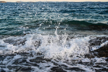 Morski valovi se razbijaju o kamenite plaže. Obala Jadranskog mora. Morska voda.