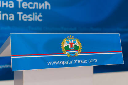 Grb Opštine Teslić na plavoj pozadini sa internet adresom Opštine Teslić. Krupni kadar.