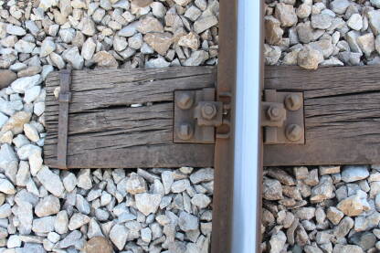 Detalj željezničke pruge. Jedan drveni prag sa okovom i metalnim spojnicama na tračnicama.