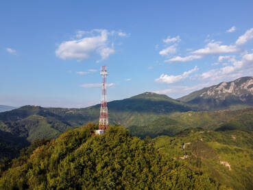 GSM i radio telekomunikacioni toranj na vrhu brda. Toranj mobilne mreže, snimak dronom iz zraka. Bazna primopredajna stanica. Bežični komunikacioni antenski predajnik.