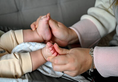Majka drži nogice svog djeteta. Mama i beba Majka drži nogice svog djeteta. Mama i beba. Roditeljstvo. Majka umiruje bebu.