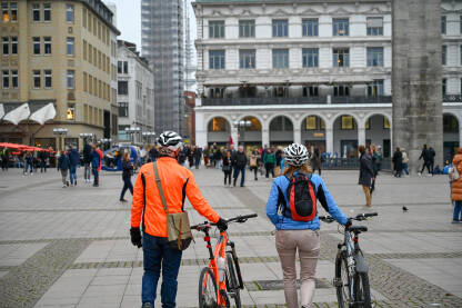 Biciklisti na trgu. Čovjek i žena sa biciklom.