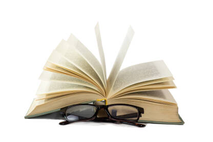 Naočale i otvorena knjiga na bijeloj pozadini