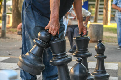 Ljudi igraju šah u gradskom parku. Gigantski šah u gradu.