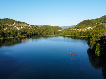 Ljudi se zabavljaju čamcu na jezeru, snimak dronom. Turisti uživaju na vodi. Ljudi na pedalini i u gumenom čamcu. Plivsko jezero.