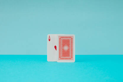 Karte za igranje s okrenutim crvenim asom srce na plavoj pozadini.