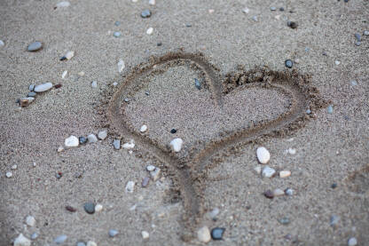 Srce nacrtano na pijesku.
Srce, kamenje i pijesak.