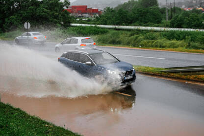 Automobil vozi kroz vodu,lokalni pljuskovi stvorili probleme u saobraćaju.