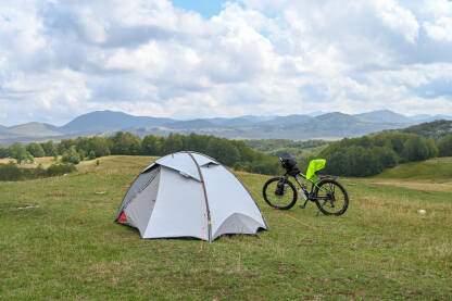 Šator i bicikl na planini. Planinari spavaju u šatoru u prirodi.