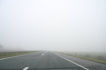 Magla. Vožnja automobila po maglovitom vremenu. Teški uslovi vožnje. Pogled na cestu kroz vjetrobransko staklo automobila. Pogled vozača.