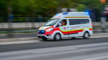 Beč, Austrija: Zamagljeni automobil hitne pomoći se kreće brzo ulicom. Hitna pomoć.
