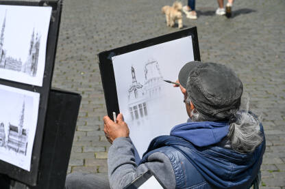 Umjetnik slika gradski krajolik. Umjetnik crta sliku u gradu.