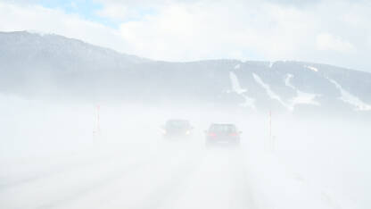 Vožnja automobila po snježnom putu. Zimska mećava. Automobili na opasnom zaleđenom i zaleđenom putu. Vožnja vozilom po mećavi