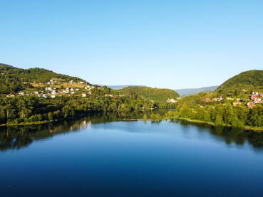 Jezero smješteno između planina, snimak dronom. Prirodno jezero između brda. Plivsko jezero, Jajce, Bosna i Hercegovina.