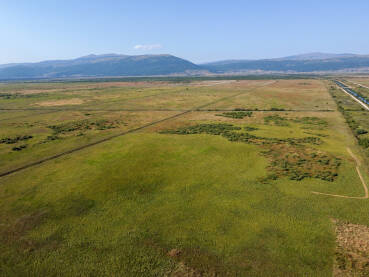Snimak prostranog krškog polja. Široki pejzaž Livanjskog polja snimljen dronom. Panorama Livanjskog polja.