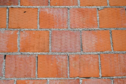 Cigle u zidu, krupni plan. Građevina. Gradnja kuće ili stana. Zidanje zida.