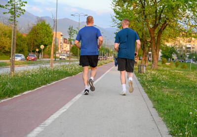 Muškarci trče na stazi u gradu. Dva muškarca treniraju. Održavanje kondicije.