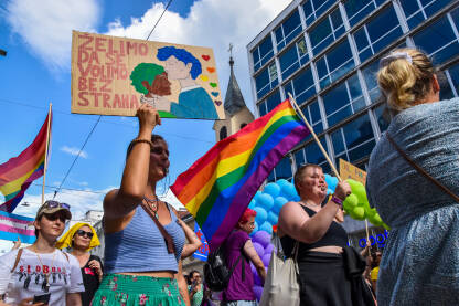 Povorka ponosa 2022, Sarajevo, Bosna i Hercegovina. Protest za jednaka prava LGBTIQ zajednice. Dugine zastave i transparenti, sa crkvom u pozadini.