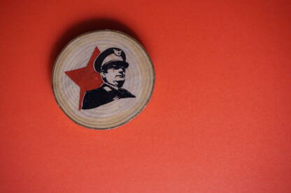 Suvenir s likom Josipa Broza Tita Suvenir s likom Josipa Broza Tita na crvenoj podlizi. Magnet, preslikana slika na komadu drveta. Tito je bio vođa jugoslavenskih partizana i predsjednik Jugoslavije