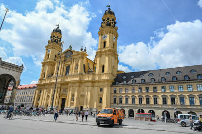 Minhen, Njemačka. Theatinerkirche je rimokatolička crkva na trgu Odeonsplatz. Crkva u centru grada i ljudi na trgu.