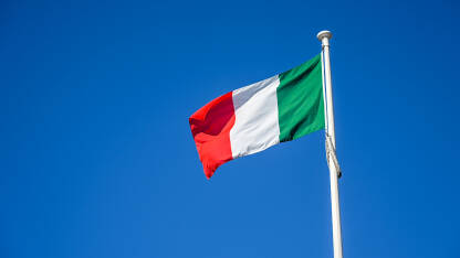 Italijanska zastava na jarbolu. Zastava Italije. Italijanska zastava na jarbolu. Zelena, bijela i crvena boja italijanske zastave. Zastava Italije naspram plavog neba.