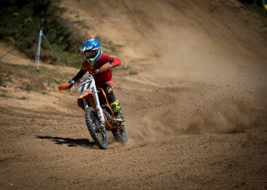 Vozač cross motora tokom trke. Motocross trka. Takmičenje u vožnji cross motora.