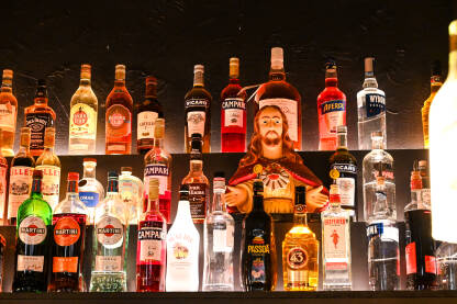 Statua Isusa Krista između boca alkoholnih pića