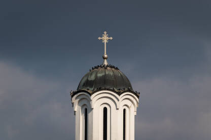 Golubovi odmaraju na krovu zvonika srpske pravoslavne crkve u Brodu naspram tamnih oblaka