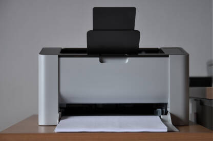 Sivi laserski štampač nasuprot bijelog zida