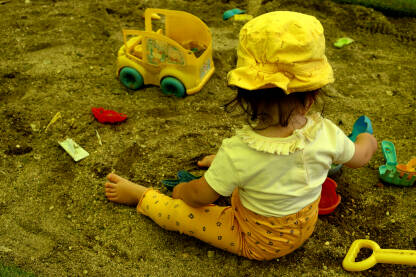 Dijete se sa igračkama igra u pijesku