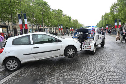 Vučno vozilo odvozi nepropisno parkiran automobil u gradu. Vozilo "pauk" u Parizu, Francuska.
