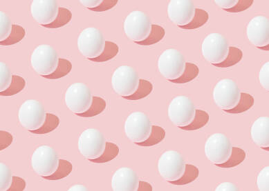 Uskršnji pozadinski uzorak s bijelim jajima na ružičastoj pozadini.