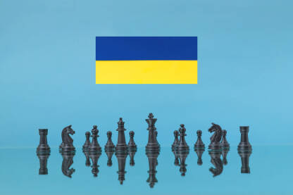Crne šahovske figure sa odrazima i zastava Ukrajine u pozadini. Šah, strategija, potezi, rat, borba, vojska, ilustracija.