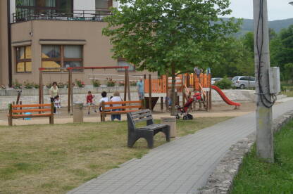 Roditelji sa svojom decom u parku za igranje