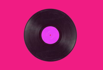 Stara gramofonska ploča, vinil, na jarkoj pink podlozi sa prostorom sa strane.