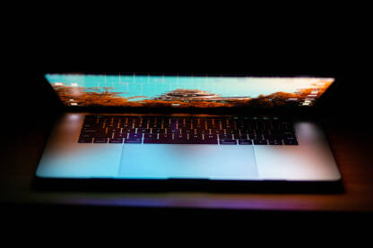 Laptop sa upaljenim ekranom na radnom stolu