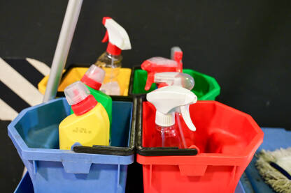 Korpa sa sredstvima za čišćenje kod kuće. Plastične boce sa sredstvom za dezinfekciju, deterdžentom i sapunom. Hemikalije za čišćenje u spreju.