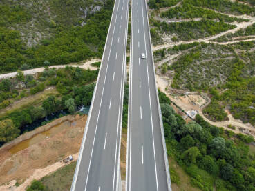 Vozila se kreću po visokom mostu na autoputu, snimak dronom. Saobraćaj na modernom vijaduktu na autoputu.