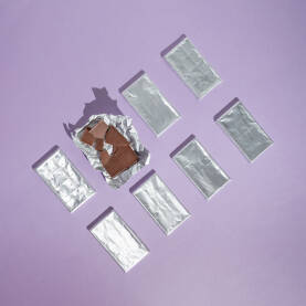 Otvorena čokolada sa nekoliko neotvorenih  u aluminijskoj srebrenoj foliji.