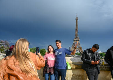 Pariz, Francuska: Turisti se fotografišu ispred Eiffelovog tornja. Popularna turistička destinacija.