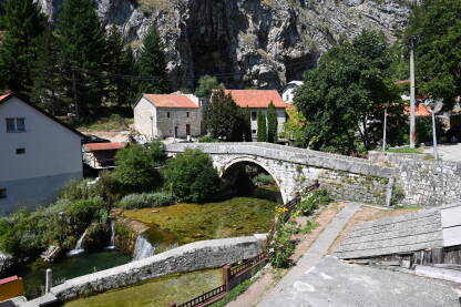 Livno, BiH: Stari kameni most iznad rijeke Bistrice. Izvor rijeke Bistrice. Duman.