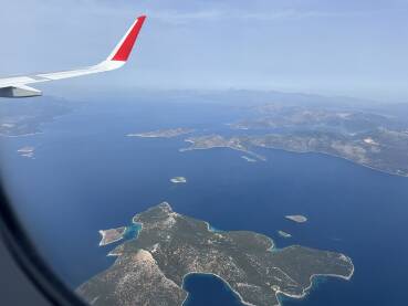Pogled s prozora aviona na nebo, more i krilo aviona.