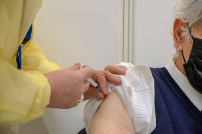 Stariji muškarac prima cjepivo u rame. Cijepljenje protiv covida. Doktor ubrizgava pacijentu antivirusno cjepivo protiv Covid-19. Cijepljenje protiv koronavirusa.