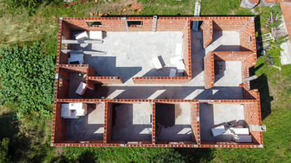 Kuća u izgradnji, snimak dronom. Izgradnja kuće na selu. Zidovi od opeke na stambenoj kući. Gradilište.